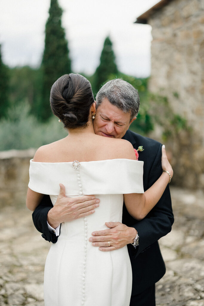 Campbell walking down the aisle during her wedding ceremony at Villa Ardore in Chianti, Tuscany, surrounded by vineyards and close family members in an intimate outdoor Italian wedding setting.