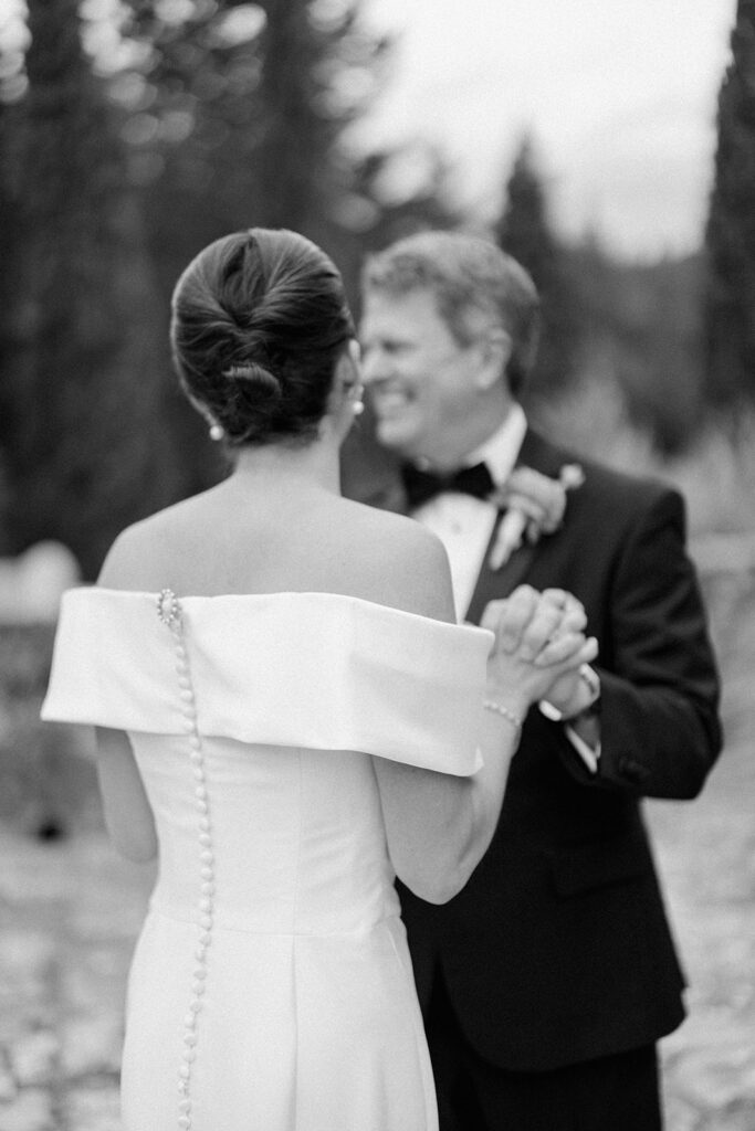 Campbell walking down the aisle during her wedding ceremony at Villa Ardore in Chianti, Tuscany, surrounded by vineyards and close family members in an intimate outdoor Italian wedding setting.