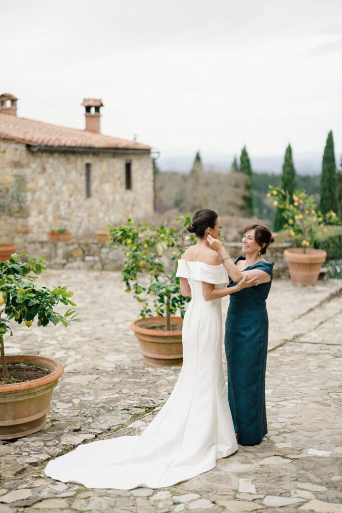 Campbell walking down the aisle during her wedding ceremony at Villa Ardore in Chianti, Tuscany, surrounded by vineyards and close family members in an intimate outdoor Italian wedding setting.