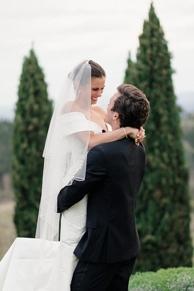 Campbell and Stuart just married at Villa Ardore in Chianti, Tuscany, walking together through the vineyards after their intimate outdoor wedding ceremony in Italy.