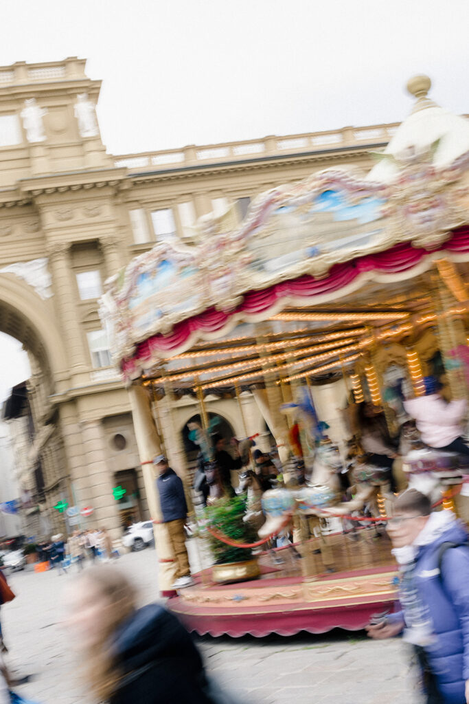 Campbell and Stuart during their engagement session in Florence, Italy, walking through historic cobblestone streets surrounded by classic Renaissance architecture at golden hour before their Tuscany wedding celebration.