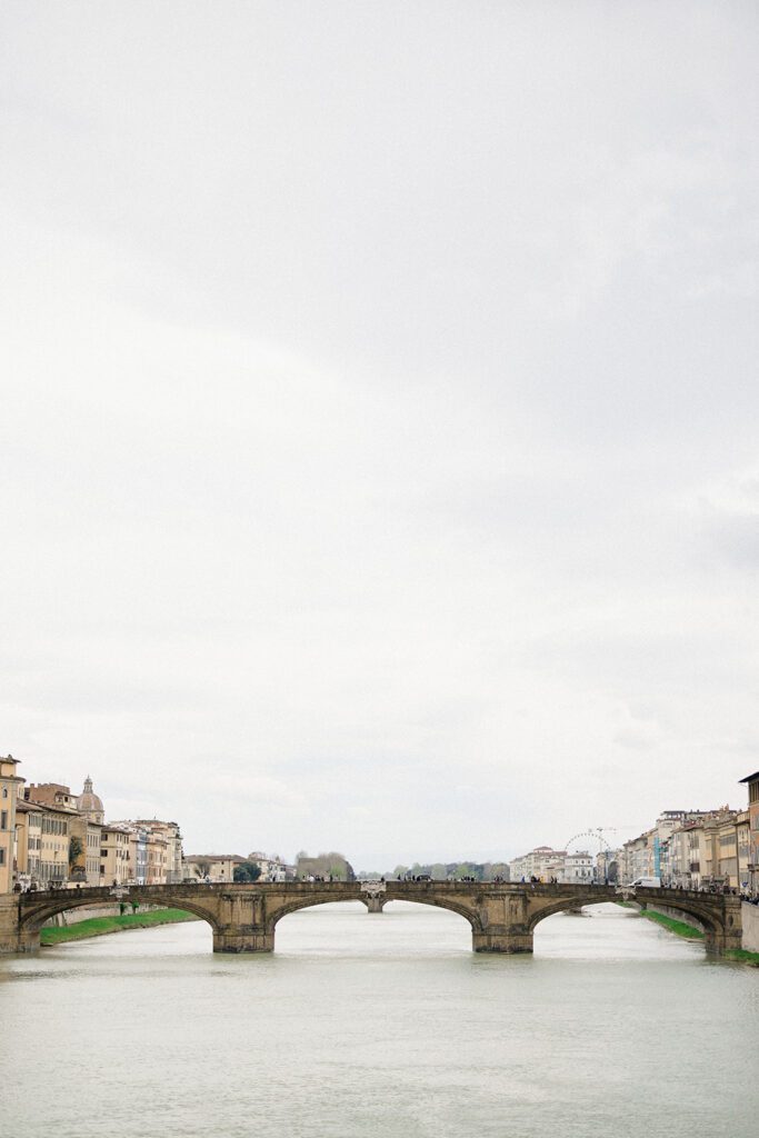 Campbell and Stuart during their engagement session in Florence, Italy, walking through historic cobblestone streets surrounded by classic Renaissance architecture at golden hour before their Tuscany wedding celebration.