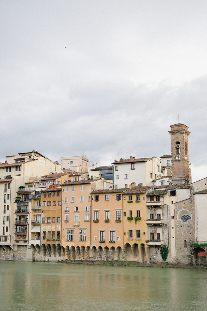 Campbell and Stuart during their engagement session in Florence, Italy, walking through historic cobblestone streets surrounded by classic Renaissance architecture at golden hour before their Tuscany wedding celebration.