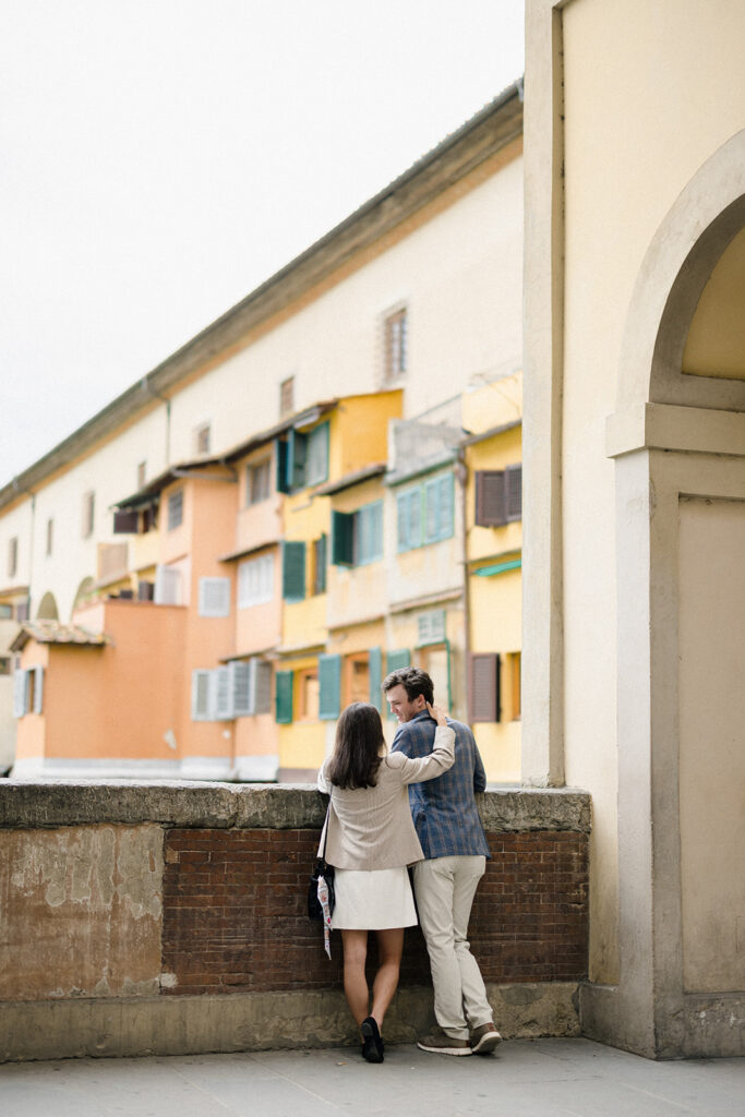 Campbell and Stuart during their engagement session in Florence, Italy, walking through historic cobblestone streets surrounded by classic Renaissance architecture at golden hour before their Tuscany wedding celebration.