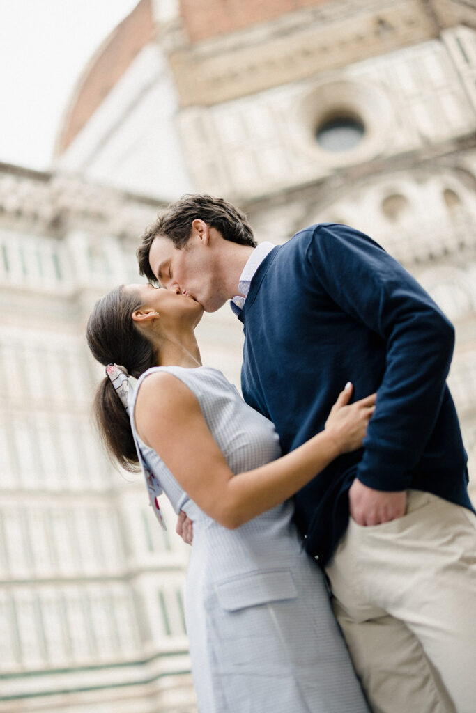 Campbell and Stuart during their engagement session in Florence, Italy, walking through historic cobblestone streets surrounded by classic Renaissance architecture at golden hour before their Tuscany wedding celebration.