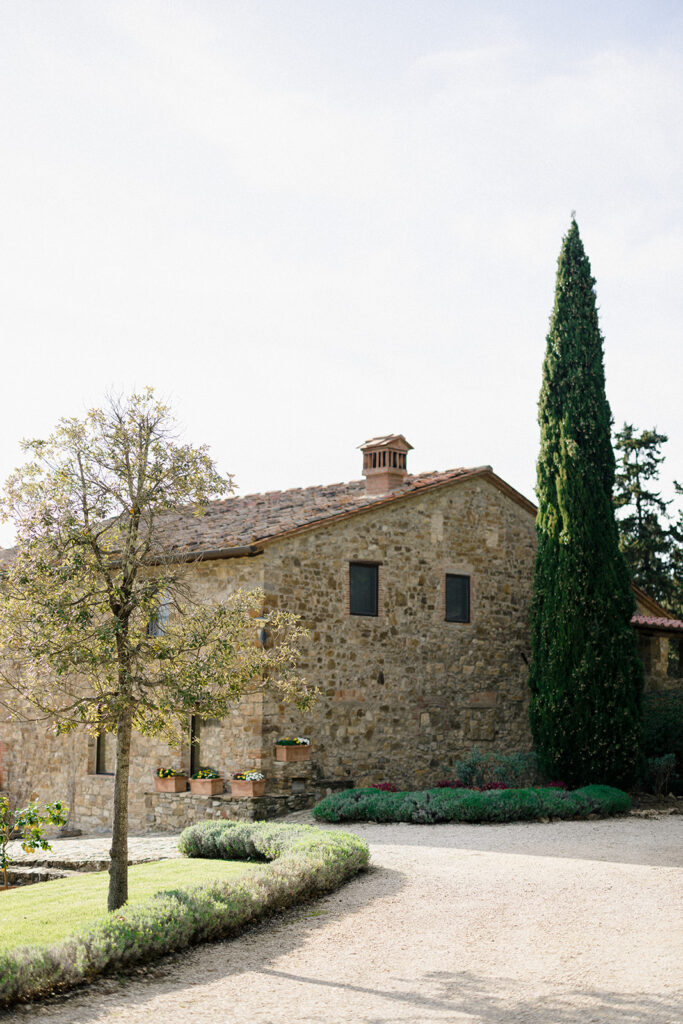 Campbell walking down the aisle during her wedding ceremony at Villa Ardore in Chianti, Tuscany, surrounded by vineyards and close family members in an intimate outdoor Italian wedding setting.