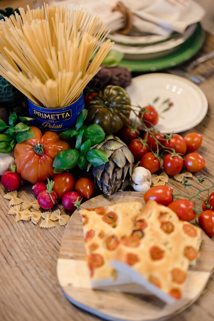 Campbell and Stuart participating in a hands-on cooking class in Italy, surrounded by family and shared laughter.