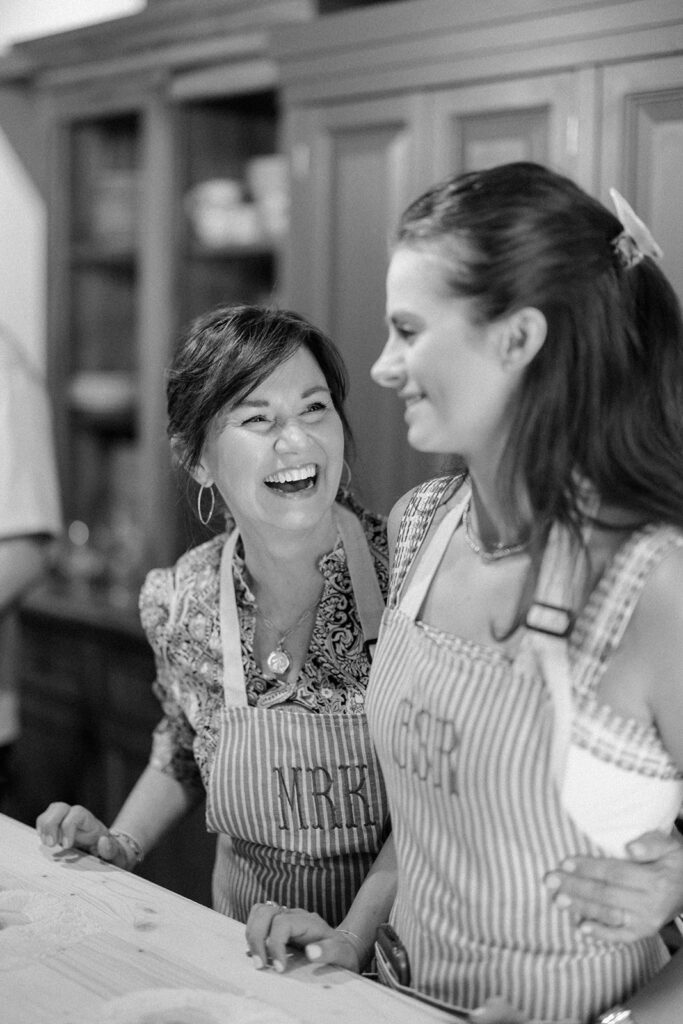 Campbell and Stuart participating in a hands-on cooking class in Italy, surrounded by family and shared laughter.