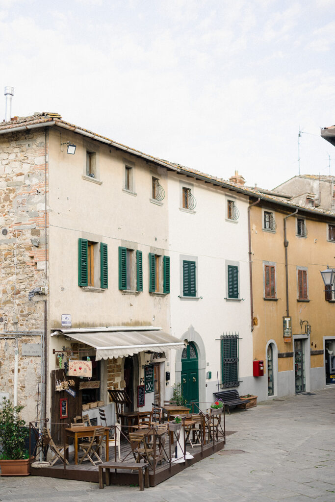 Campbell and Stuart during their engagement session in Florence, Italy, walking through historic cobblestone streets surrounded by classic Renaissance architecture at golden hour before their Tuscany wedding celebration.