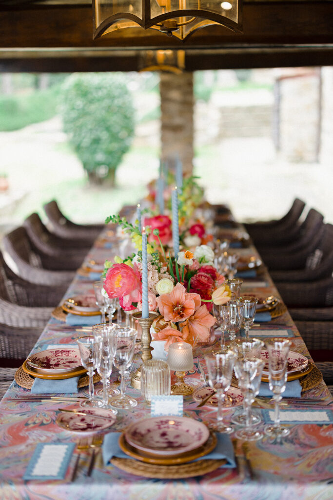 Candlelit wedding reception dinner at Villa Ardore in Chianti, Tuscany, with long tables, vibrant florals by Tuscany Flowers, and family gathered together overlooking the Tuscan hills at sunset.