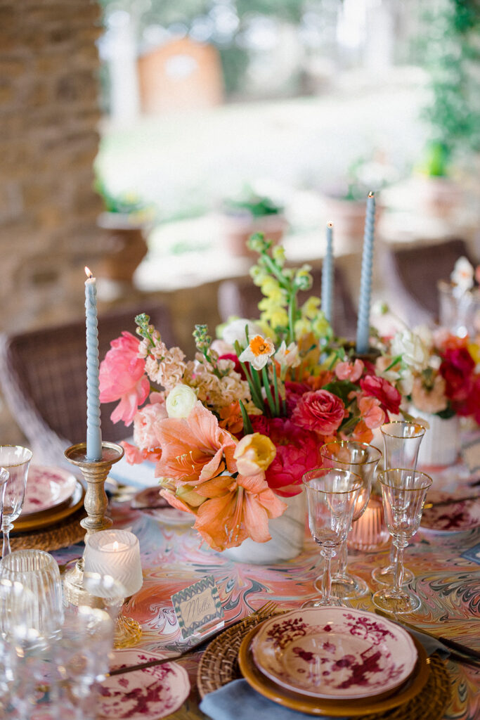 Candlelit wedding reception dinner at Villa Ardore in Chianti, Tuscany, with long tables, vibrant florals by Tuscany Flowers, and family gathered together overlooking the Tuscan hills at sunset.