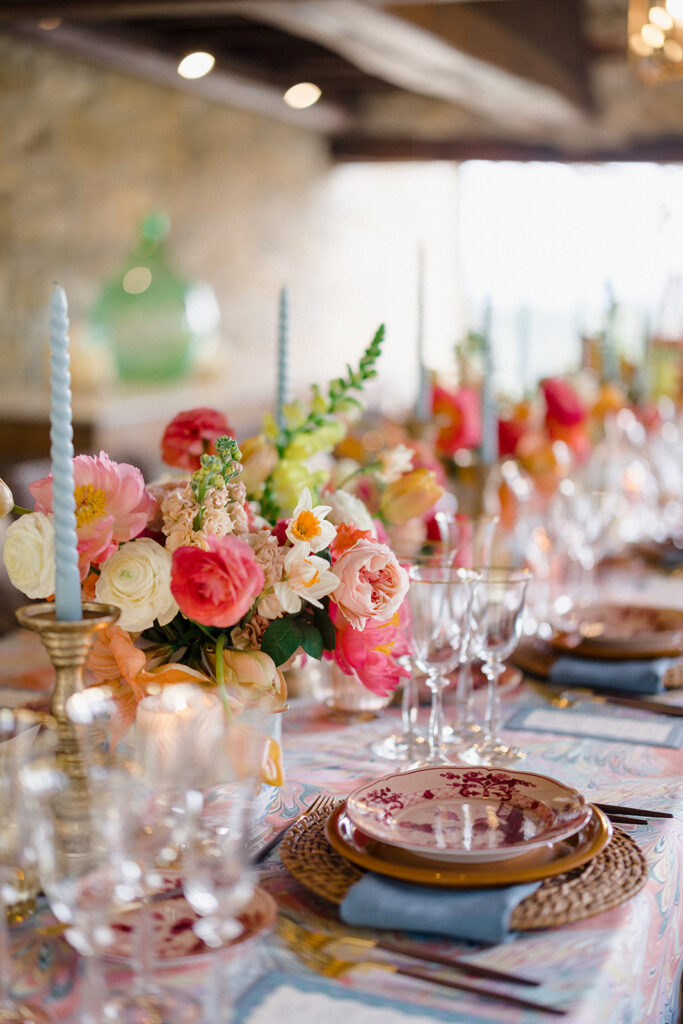 Candlelit wedding reception dinner at Villa Ardore in Chianti, Tuscany, with long tables, vibrant florals by Tuscany Flowers, and family gathered together overlooking the Tuscan hills at sunset.