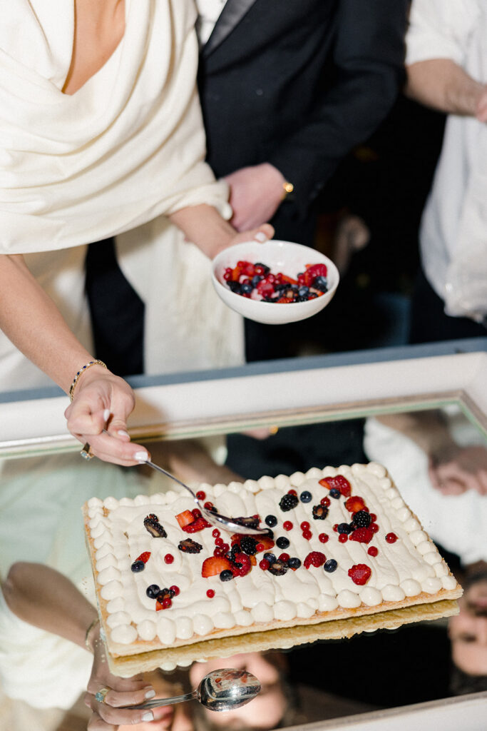 Candlelit wedding reception dinner at Villa Ardore in Chianti, Tuscany, with long tables, vibrant florals by Tuscany Flowers, and family gathered together overlooking the Tuscan hills at sunset.