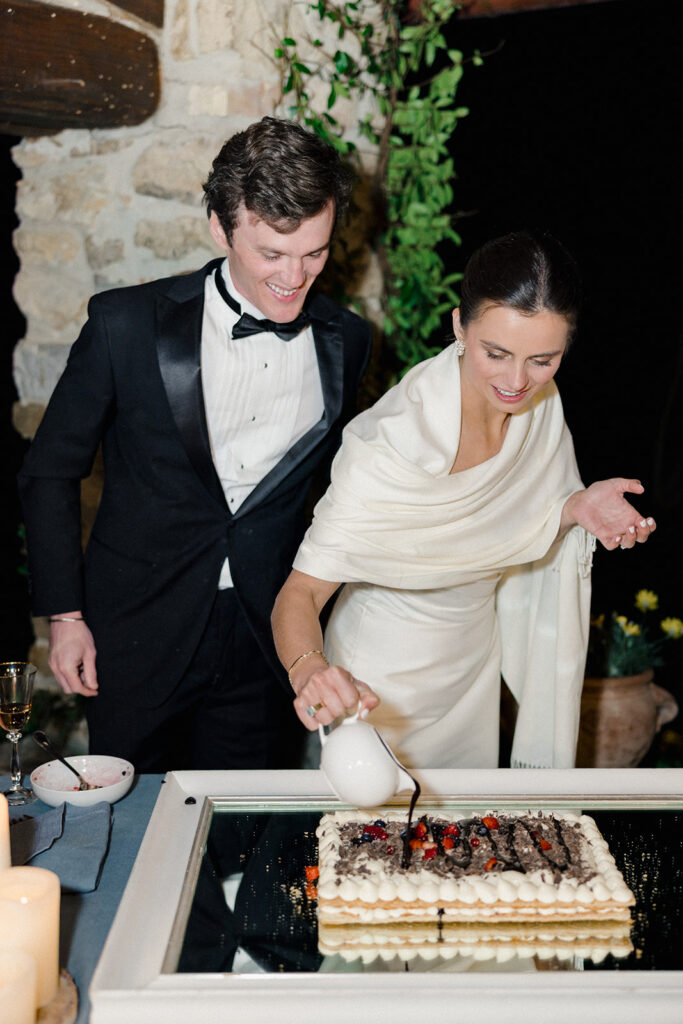 Candlelit wedding reception dinner at Villa Ardore in Chianti, Tuscany, with long tables, vibrant florals by Tuscany Flowers, and family gathered together overlooking the Tuscan hills at sunset.