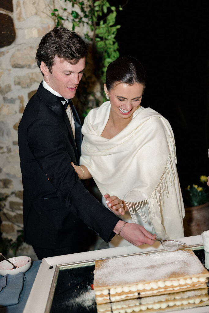 Candlelit wedding reception dinner at Villa Ardore in Chianti, Tuscany, with long tables, vibrant florals by Tuscany Flowers, and family gathered together overlooking the Tuscan hills at sunset.