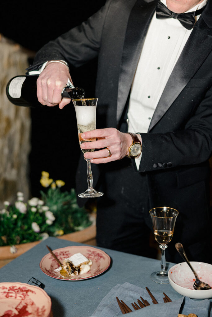 Candlelit wedding reception dinner at Villa Ardore in Chianti, Tuscany, with long tables, vibrant florals by Tuscany Flowers, and family gathered together overlooking the Tuscan hills at sunset.