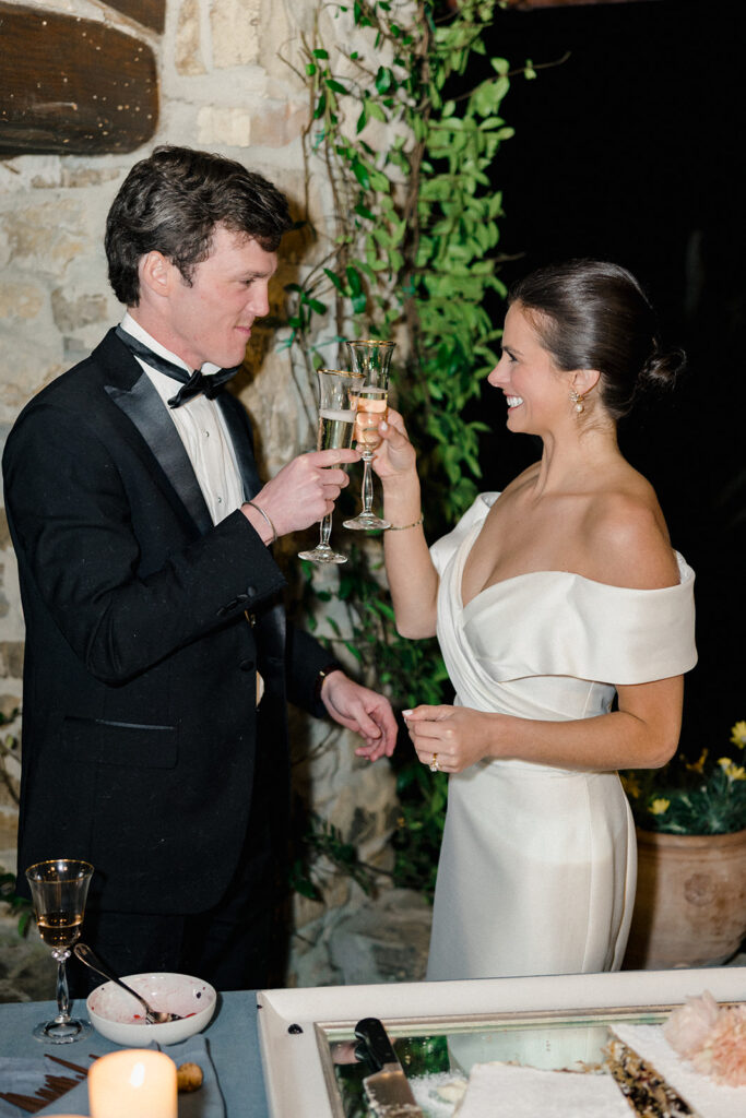 Candlelit wedding reception dinner at Villa Ardore in Chianti, Tuscany, with long tables, vibrant florals by Tuscany Flowers, and family gathered together overlooking the Tuscan hills at sunset.