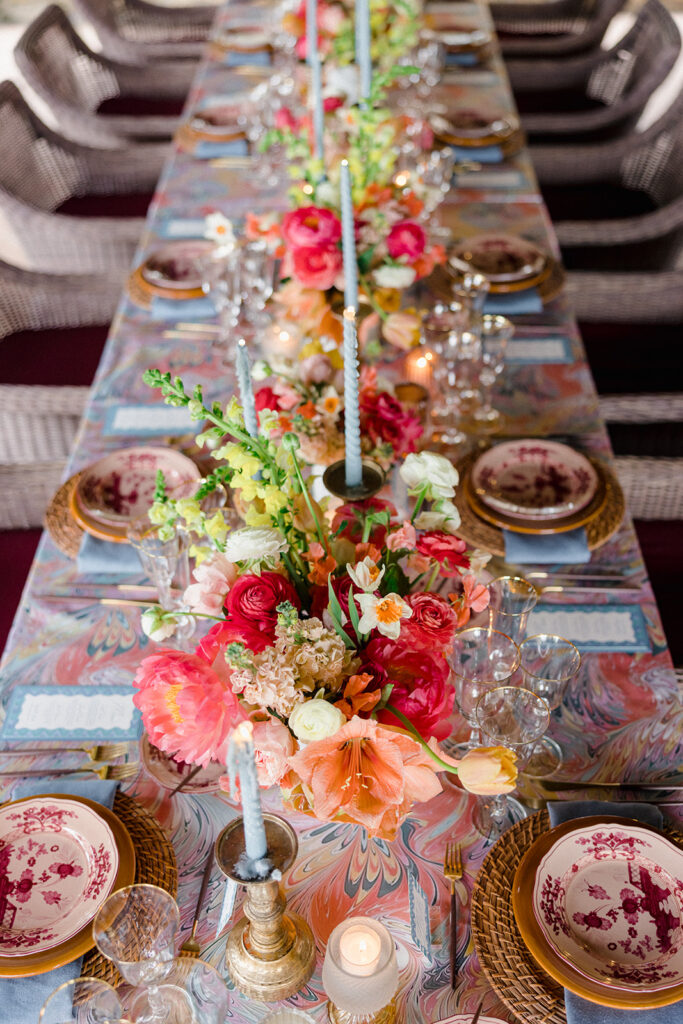 Candlelit wedding reception dinner at Villa Ardore in Chianti, Tuscany, with long tables, vibrant florals by Tuscany Flowers, and family gathered together overlooking the Tuscan hills at sunset.