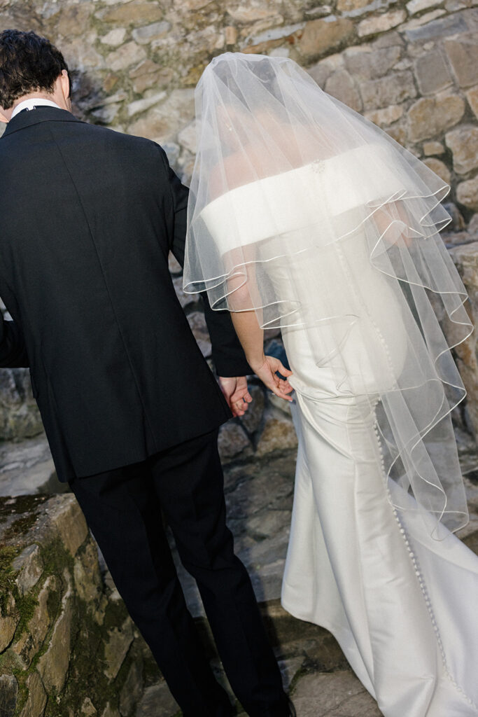 Campbell and Stuart just married at Villa Ardore in Chianti, Tuscany, walking together through the vineyards after their intimate outdoor wedding ceremony in Italy.