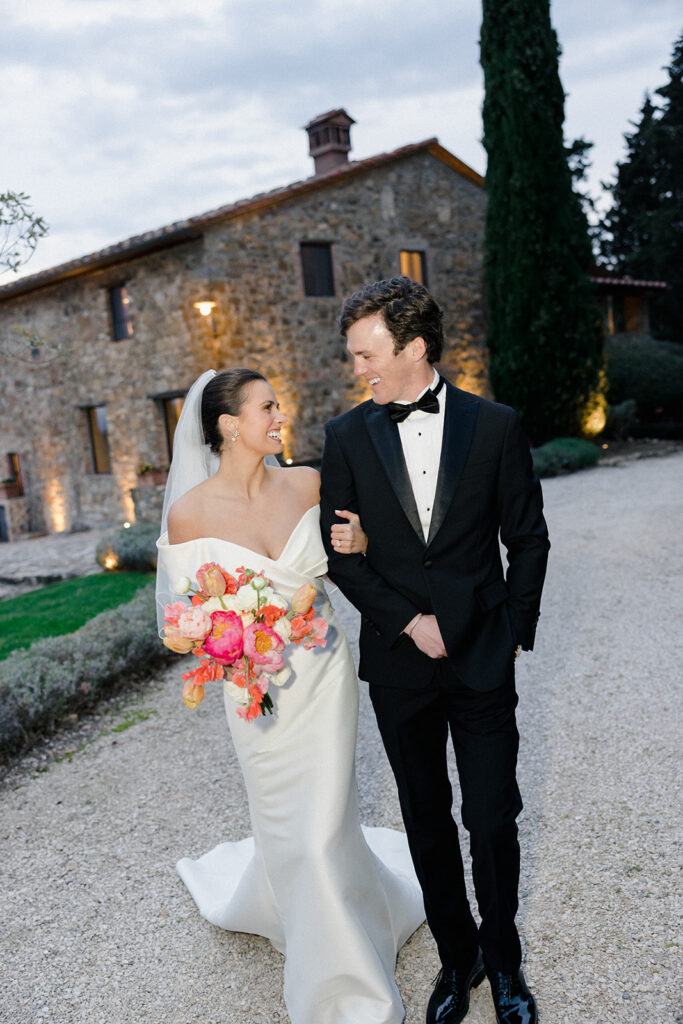 Campbell and Stuart just married at Villa Ardore in Chianti, Tuscany, walking together through the vineyards after their intimate outdoor wedding ceremony in Italy.